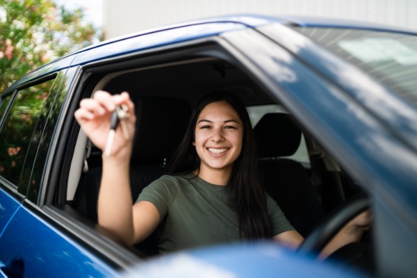 Girl in car holding up keys